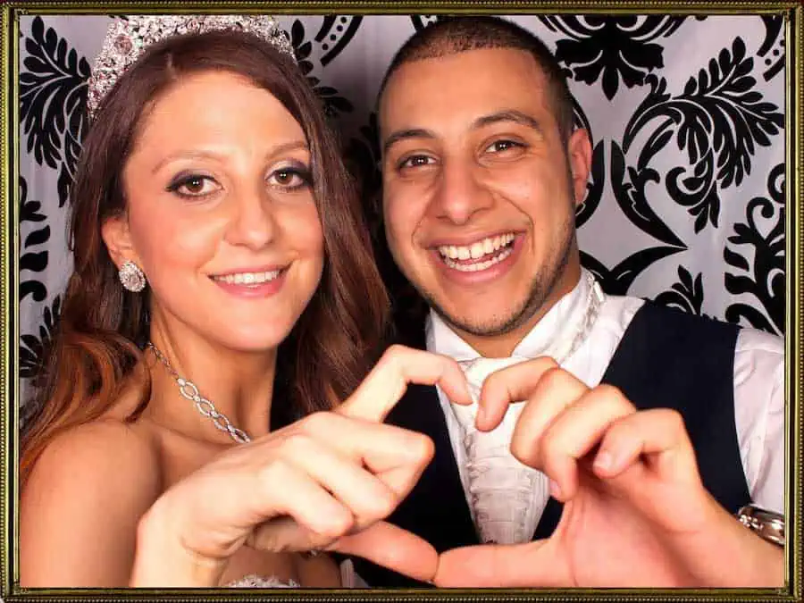 Glam Photobooths - Attractive Newlyweds Making Heart Signs in a Photo Booth