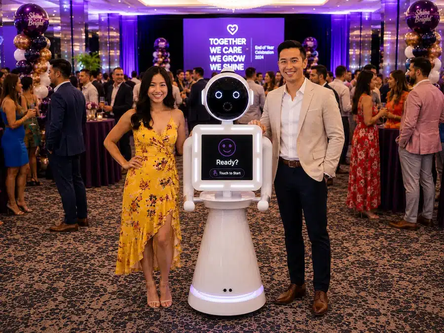 Guests posing beside the Glam Photobooths Robot Photo Booth at a Melbourne corporate event.